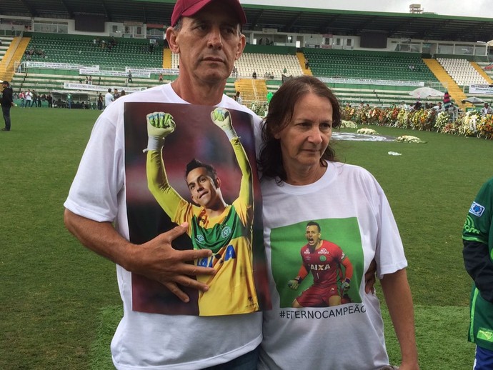 Os pais do goleiro Danilo com a imagem do filho na Arena Condá (Foto - David Abramvezt)